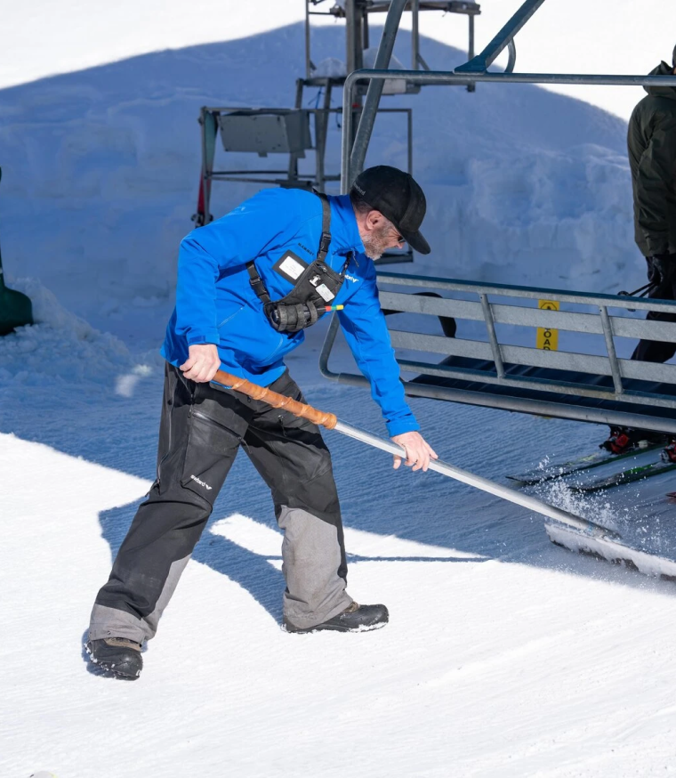 lift worker cleaning snow
